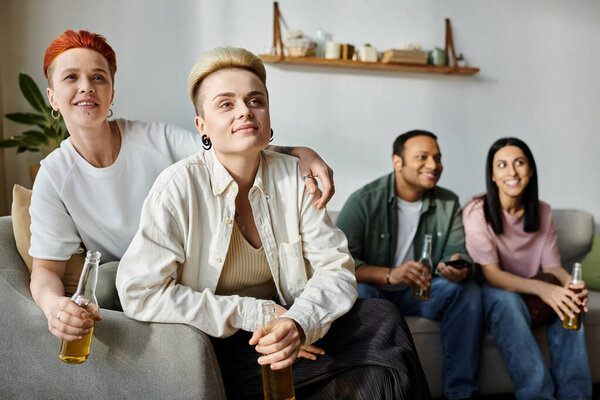 Diverse group of friends, with a loving lesbian couple, relax and converse on top of a couch.