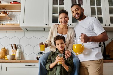 Mutlu bir Afrikalı Amerikalı aile mutfakta birlikte yemek pişiriyor..