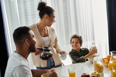Afro-Amerikan bir aile masada birlikte yemek yiyor..