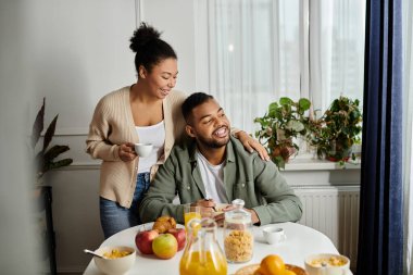 A man and woman enjoy a meal together at a table. clipart