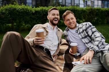 İki adam, rahat bir battaniyede yan yana dinleniyor..