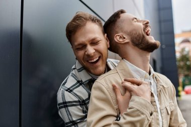 Samimi kıyafetli iki adam gökyüzünün altında mutlu bir anı paylaşıyor..