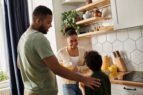 Мужчина и женщина, вместе с ребенком, стоят на теплой кухне.