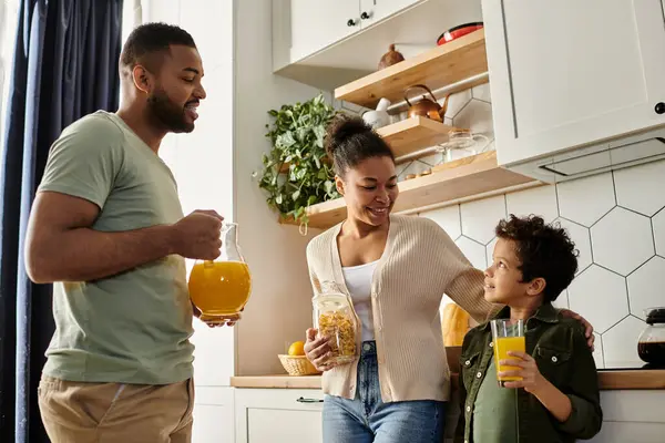 stock image African American man, woman, child happily standing in kitchen.