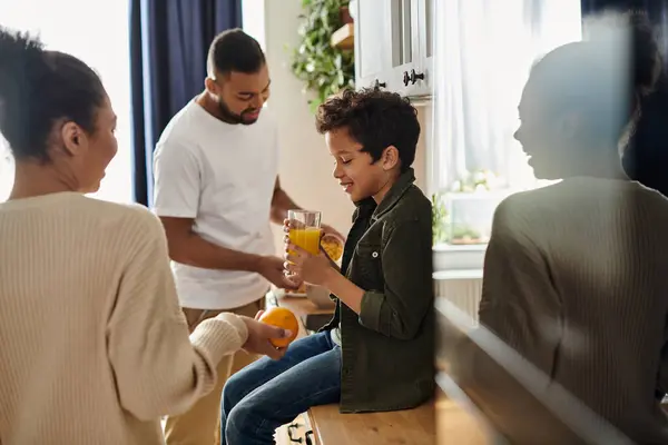 stock image An African American family enjoying time together around the kitchen counter.