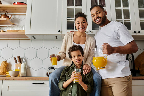 A happy African American family cooking together in a kitchen.