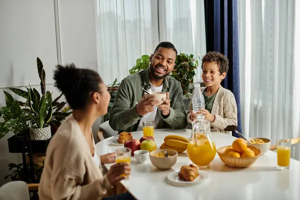 stock image African american family enjoying a meal together at a table.