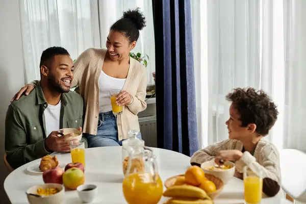 stock image African american family at a table sharing a meal and enjoying each others company.