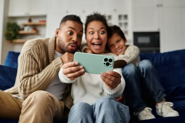 stock image A man and woman taking a picture with a cell phone, with son.