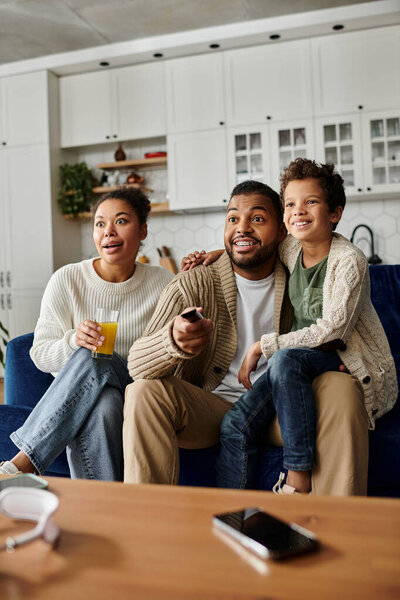 Афроамериканская семья наслаждается временем вместе на уютном диване в гостиной.
