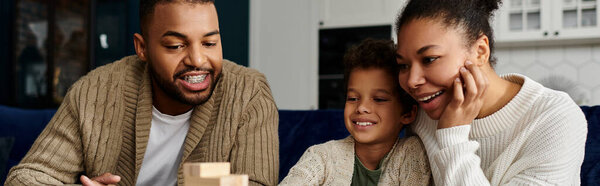 Афроамериканец и женщина с ребенком играют в игры.