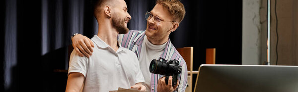 Двое мужчин, одетых в удобный наряд, стоят перед ноутбуком, погруженные в совместную работу.