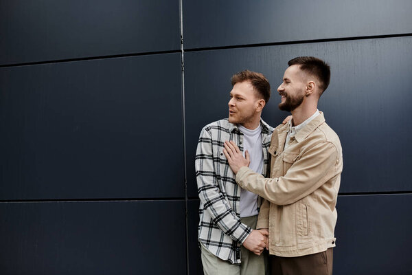 Two men in casual clothing standing close, radiating happiness and connection.