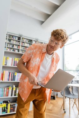 Genç adam Kütüphane içinde laptop ile eğitim.