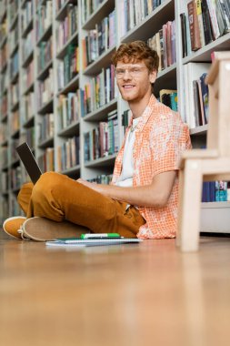 A man, a laptop, deep in thought on the floor. clipart