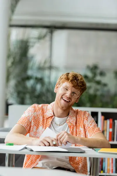 Stock image A man engrossed in reading a book at a table.