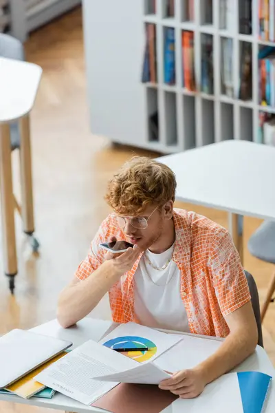 stock image A man passionately conversing on a cell phone at a table.