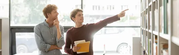 Stock image Two male students in a quiet library setting.