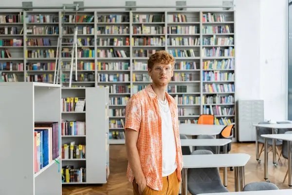 stock image A man absorbed in books at a library.