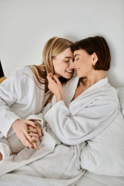 İki kadın gibi huzurlu bir an, güzel bir lezbiyen çift, otel odasındaki bir yatakta beyaz elbiseler içinde..