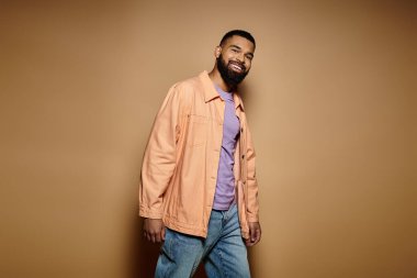Hareketli bir duvarın önünde şık giyinmiş yakışıklı Afro-Amerikan bir adam..