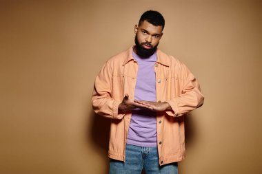 Parlak arka plana karşı elleri ceplerinde duran yakışıklı adam..