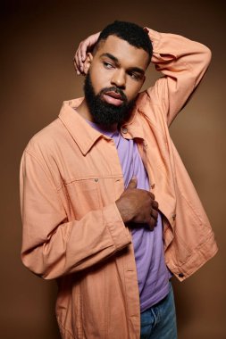 Pembe gömlekli, kendine güvenen Afro-Amerikan bir adam..