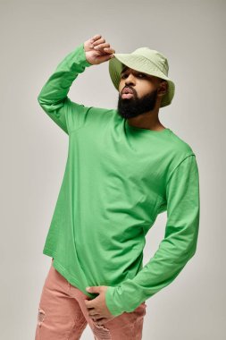 Yakışıklı Afro-Amerikalı şık giyinmiş adam canlı arka planda poz veriyor..