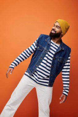 Yakışıklı Afro-Amerikan adam şık bir kot ceket ve çizgili gömlekle poz veriyor..