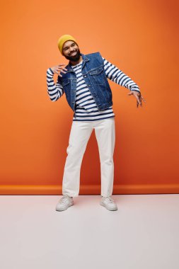 Handsome African American man in striped shirt and jean jacket posing on a vibrant backdrop. clipart