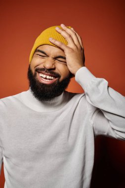 Sivri sarı şapkalı, sakallı Afro-Amerikan bir adam..