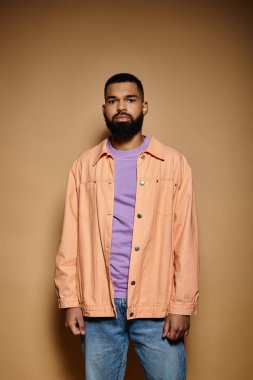 Renkli duvarın önünde sakallı şık bir adam..