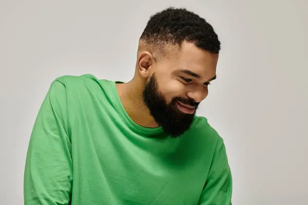 stock image Handsome African American man in a trendy green shirt poses against a vibrant backdrop.