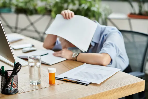 stock image A middle aged businesswoman with short hair sitting at a desk, busy working on a computer surrounded by papers.