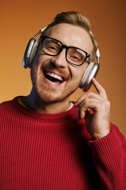 Şık gözlüklü ve kulaklıklı yakışıklı adam ışıl ışıl gülümsüyor..