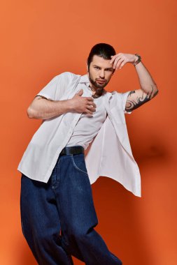 Beyaz gömlekli ve kot pantolonlu yakışıklı beyaz bir adam..