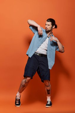 Modaya uygun mavi gömlekli ve şortlu beyaz adam kendine güveniyor..