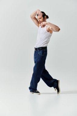 Beyaz askılı şık bir adam güven içinde dans ediyor..