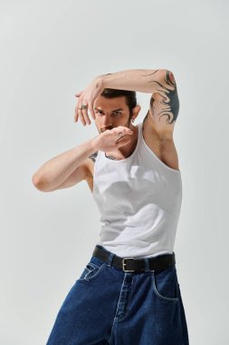 Beyaz atlet ve kot pantolon giyen yakışıklı beyaz tenli adam..