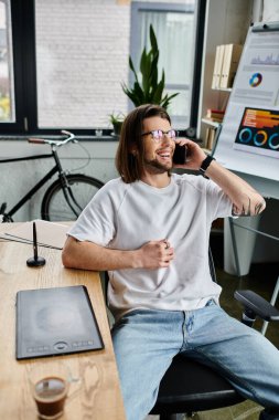 Kafkas işadamı büro masasında cep telefonuyla konuşuyor..