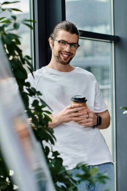 Beyaz gömlekli beyaz bir işadamı bir fincan kahvenin keyfini çıkarıyor..