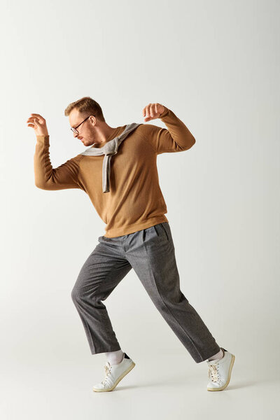Красивый мужчина в коричневой рубашке энергично танцует со стилем.