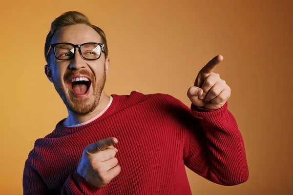 stock image Confident man in red sweater gestures excitedly.