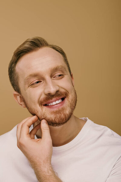 Stylish man with a goatee smiles warmly.