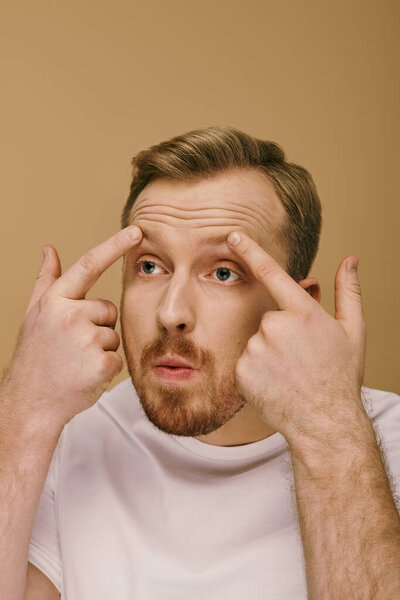 Стильный мужчина в беде, руки прижаты к его лицу.