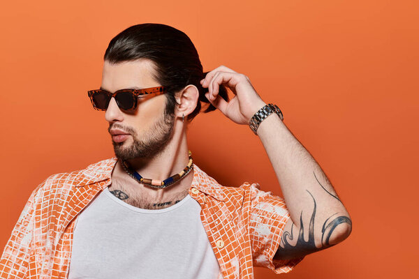 Handsome caucasian man wearing sunglasses and a necklace.