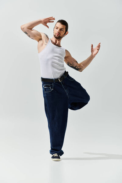 Кавказский мужчина изящно танцует в белой майке.