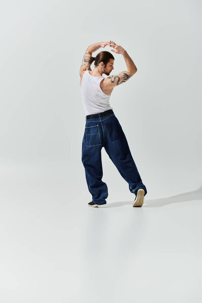 Красивый белый мужчина в модном наряде, танцующий свободно и энергично.