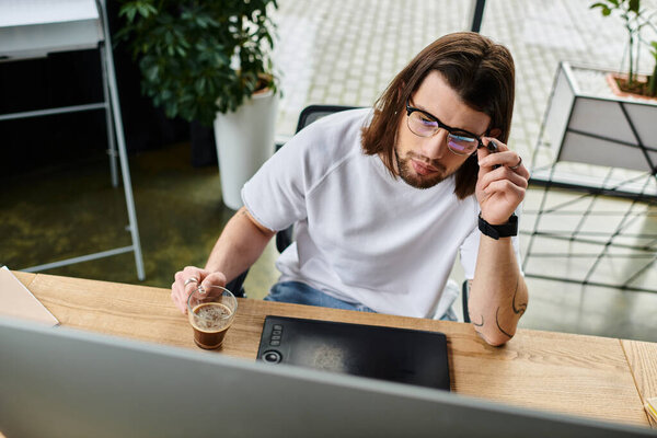 A man, a desk, a laptop, deep in concentration.