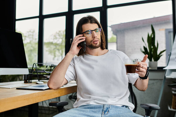 A Caucasian businessman sits at his desk, engrossed in conversation on his cell phone.
